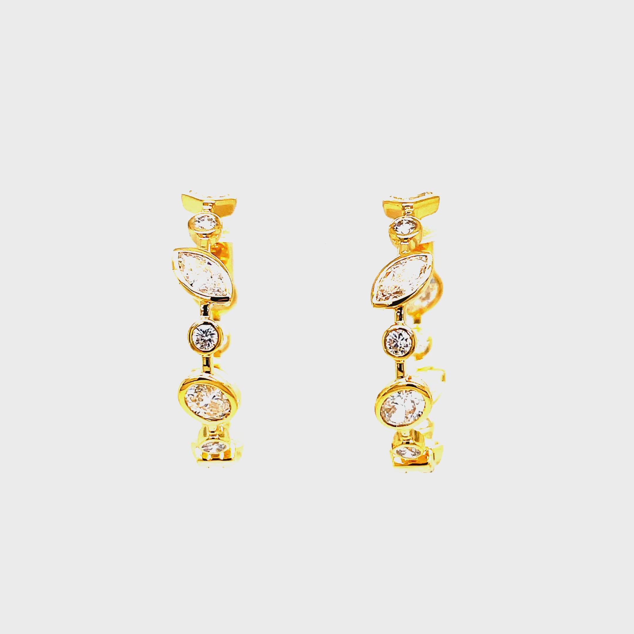 Upgrade your jewelry collection with our exclusive 18K Yellow Gold Mix Cut Bezel Set Diamond Hoop Earrings. Handcrafted with 2.14 carats of emerald, marquise, baguette, and round cut diamonds, these earrings radiate sophistication. The secure clasp system ensures durability, while the inside out diamonds add a subtle yet luxurious touch. Elevate any outfit with these elegant and timeless earrings.