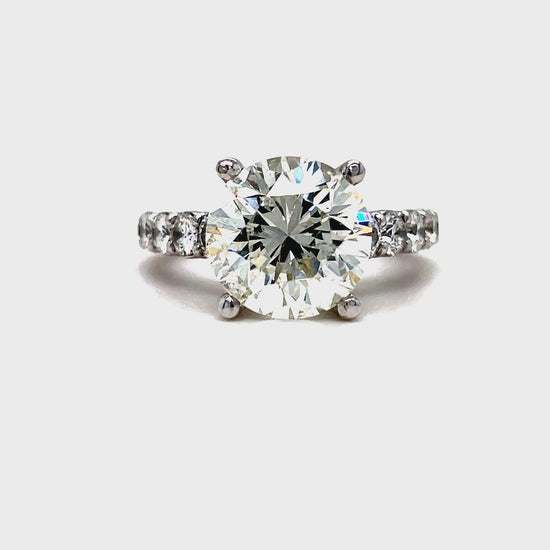 Indulge in luxury with our exclusive Custom Made Round Cut Engagement Ring. Featuring a dazzling round brilliant diamond weighing 4.56 cts, accompanied by 1.50 cts of graduated round diamonds on the side. Crafted in 18k white gold, this ring exudes elegance and sophistication. A true reflection of your love.