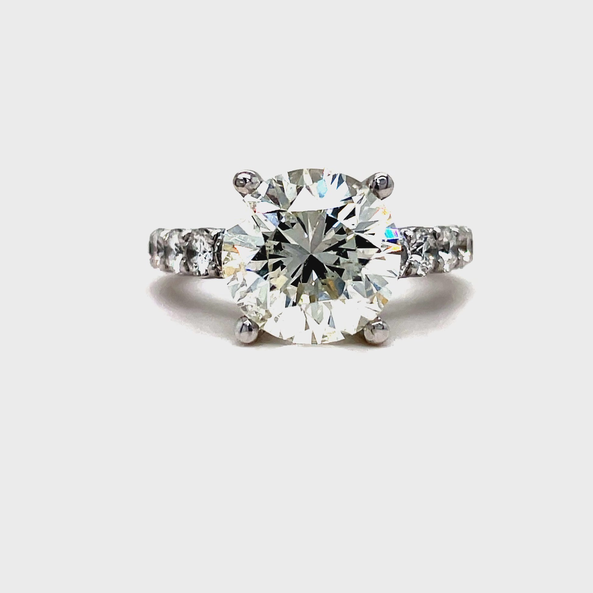 Indulge in luxury with our exclusive Custom Made Round Cut Engagement Ring. Featuring a dazzling round brilliant diamond weighing 4.56 cts, accompanied by 1.50 cts of graduated round diamonds on the side. Crafted in 18k white gold, this ring exudes elegance and sophistication. A true reflection of your love.