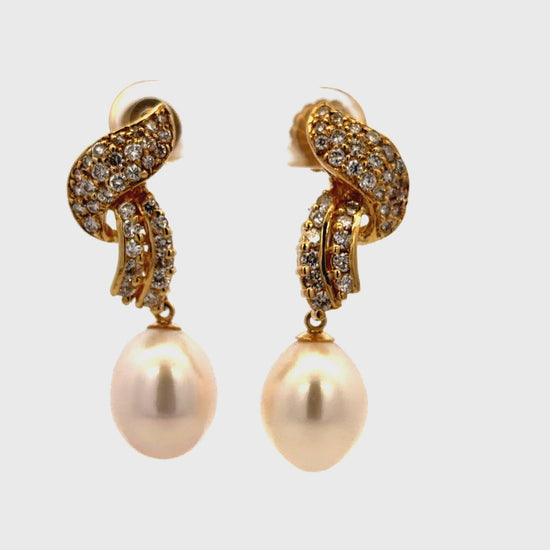 Try on view of 14k Yellow Gold diamond Pave Ribbon and Fresh Water Pearl Drop Earrings