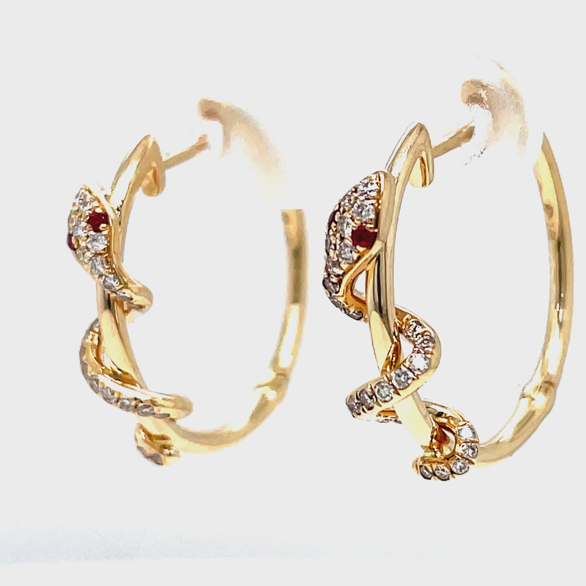 ndulge in luxury with our 14k yellow gold hoop earrings featuring round diamonds and ruby gems for the eyes of a stunning snake. The secure latch system adds ease and sophistication to these exclusive earrings. Elevate your style with 0.23 cts of sparkling diamonds.