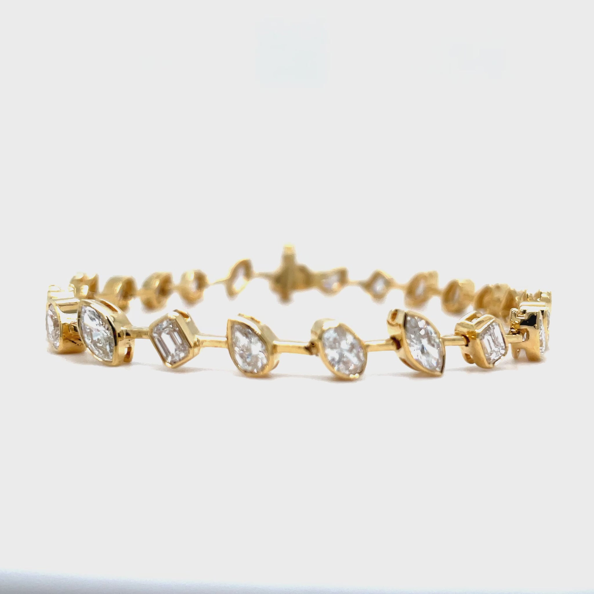 Indulge in luxury with our Mixed Fancy Cut Slant Diamond Bracelet. The unique and modern design features a mixed variety of fancy cut diamonds in pear, oval, emerald, and round shapes, all set in 18k yellow gold. With a dazzling F/G color and VS1 clarity, this bracelet is a true symbol of sophistication. Securely fastened with a clasp, it measures 7 inches in length. Elevate your style with this exquisite piece.