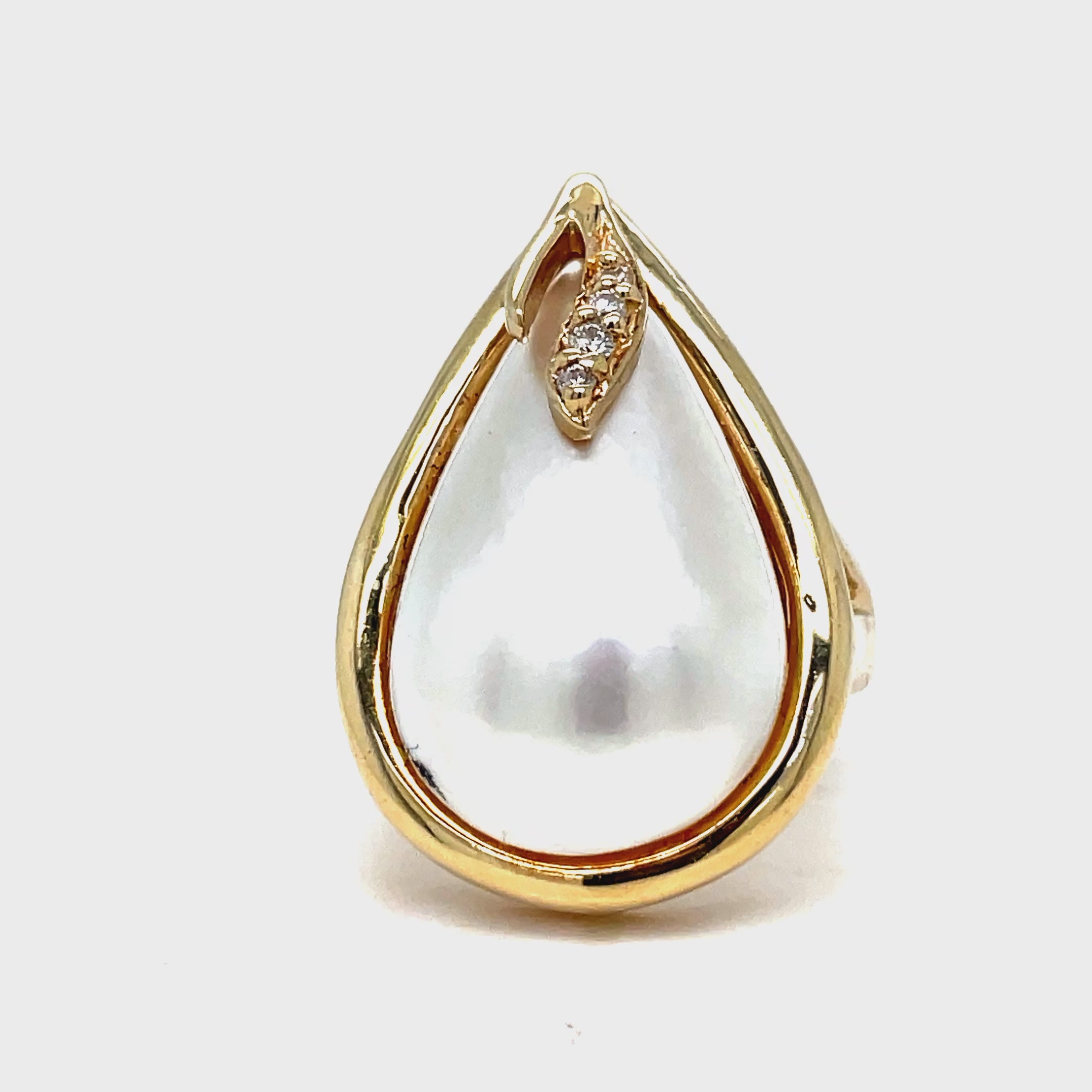 Indulge in timeless elegance with our Pear Shape Mabe Pearl Yellow Gold Ring. Crafted in 14k yellow gold, the pear-shaped Mabe pearl sits delicately atop a bed of round diamonds. This luxurious ring is the perfect accessory for any occasion.