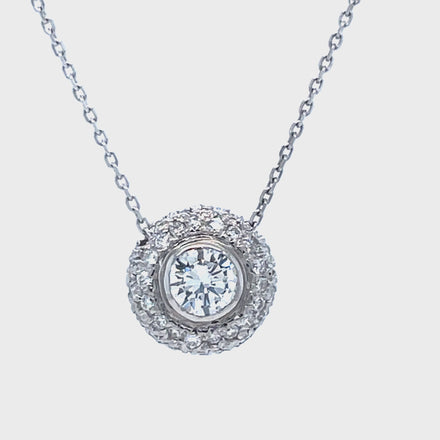 This luxurious diamond pendant necklace is crafted for brilliance and lasting beauty. It features a sparkling round 0.71 ct diamond solitaire at the center, surrounded by 0.50 cts of diamond pave setting. Set in 14k white gold, it also includes an 18" chain with a sizing loop at 16".