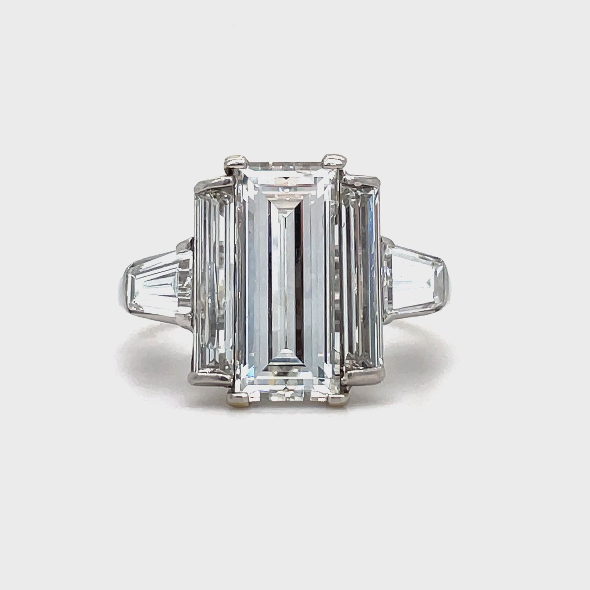 his exquisite ring exudes elegance and sophistication. The emerald cut diamond, boasting a stunning 2.53 carats and a G color grade, is complemented by two baguette diamonds and two trillion diamonds, all totaling 0.90 and 0.80 carats respectively. Crafted in platinum, this ring is a true work of art.