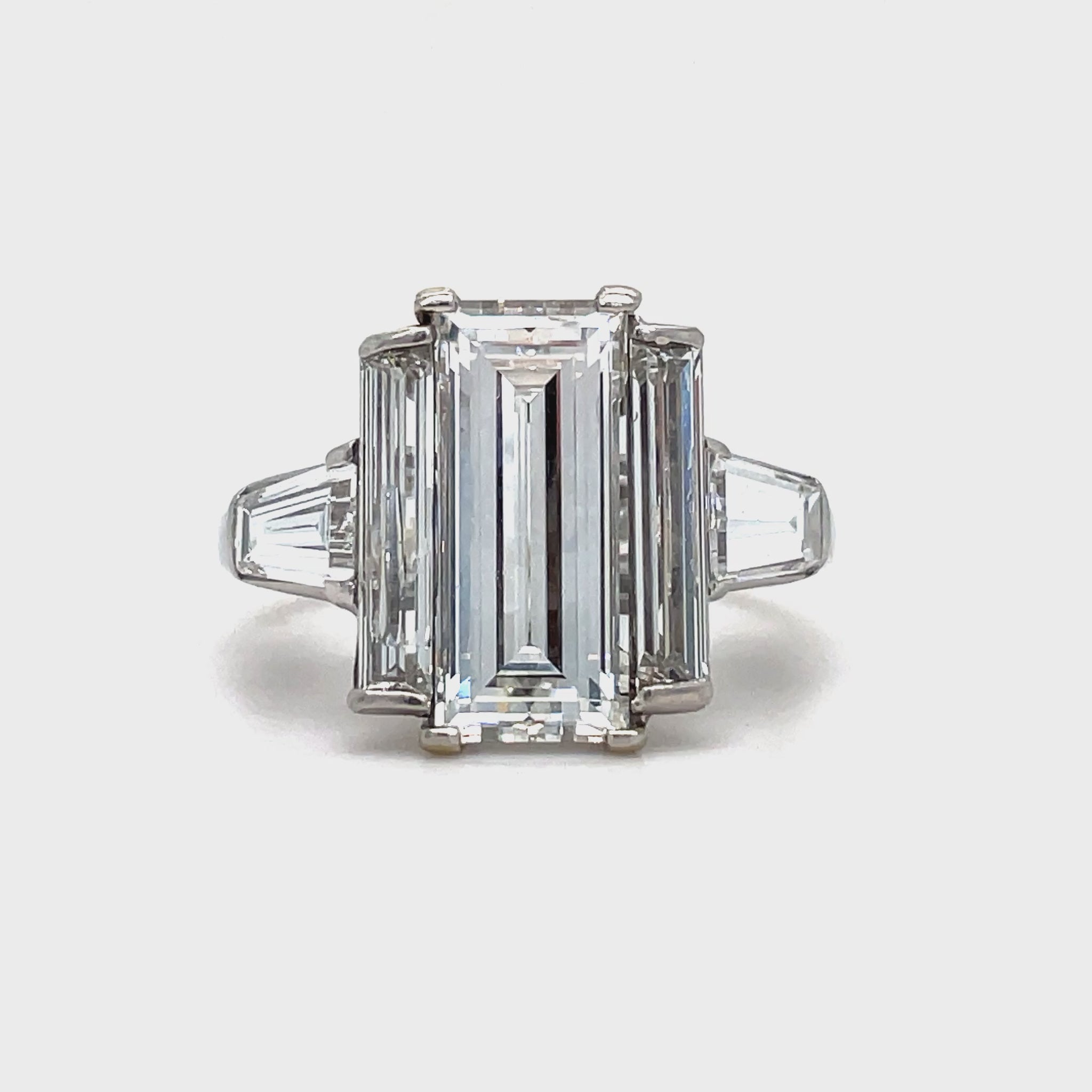 his exquisite ring exudes elegance and sophistication. The emerald cut diamond, boasting a stunning 2.53 carats and a G color grade, is complemented by two baguette diamonds and two trillion diamonds, all totaling 0.90 and 0.80 carats respectively. Crafted in platinum, this ring is a true work of art.