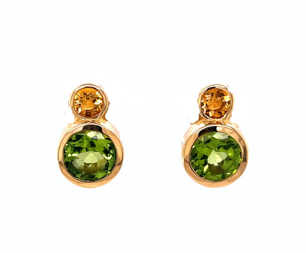 This beautiful pair of earrings is crafted in 18-karat yellow gold, and features a round Citrine stone and a round Peridot stone secured with friction backs. The earrings measure 15mm in length.