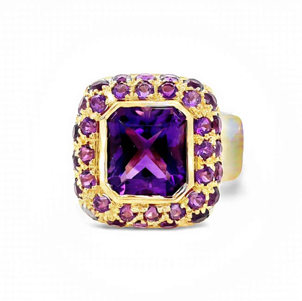 A beautiful and regally cut Italian emerald-cut amethyst is set in an ornate 18K gold shank (18.00 mm) and surrounded by amethyst pavé, giving it an eye-catching sparkle. With a size that's customizable, this ring will be an elegant and unforgettable addition to your jewelry collection. Size 7.