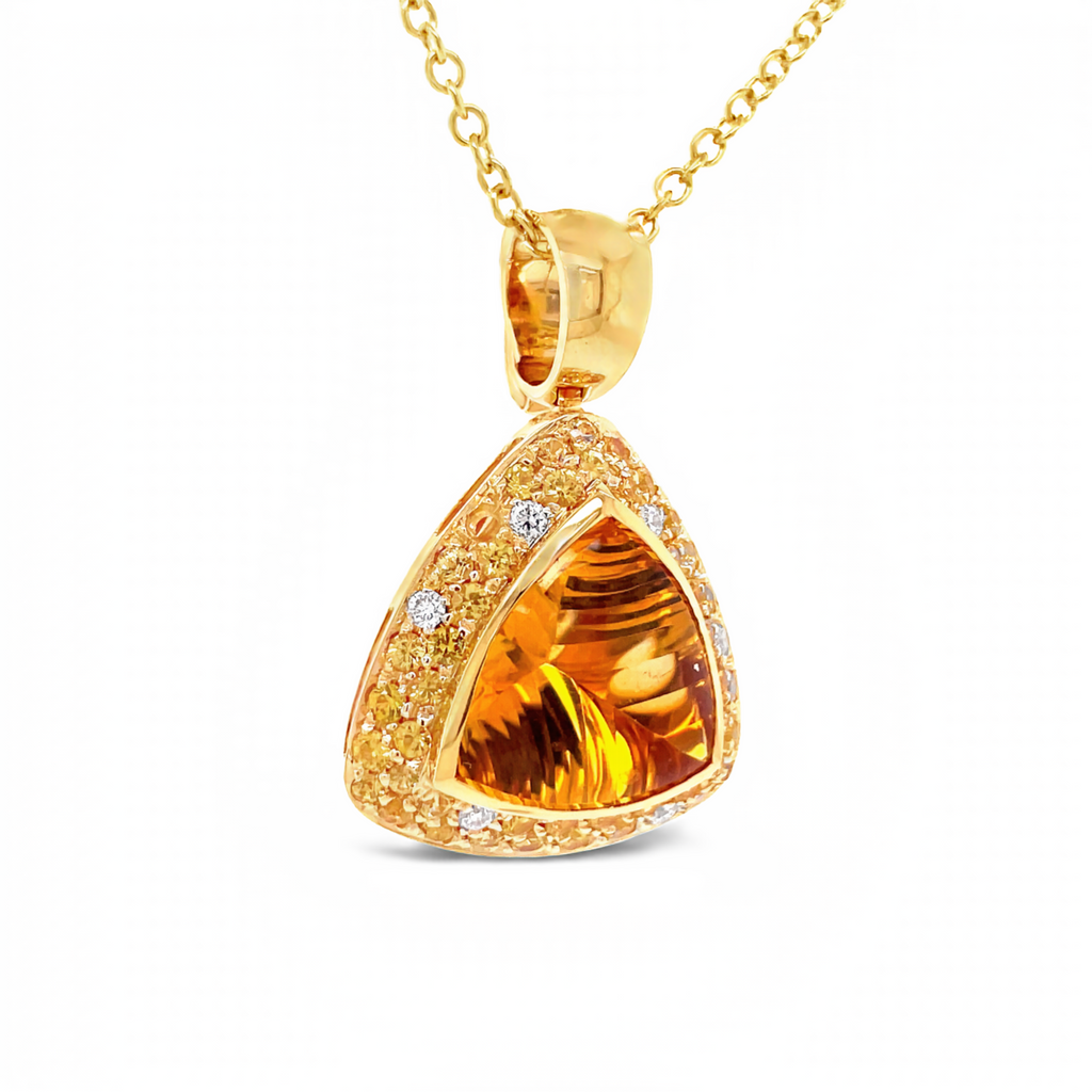 Italian made  Faceted citrine trillion shape 7.48 cts  30.00 x 20.00 mm  Set in 18k yellow gold mounting  White round diamonds 0.15 cts  Yellow sapphires 1.29 cts   Enhancer   Gallery finish