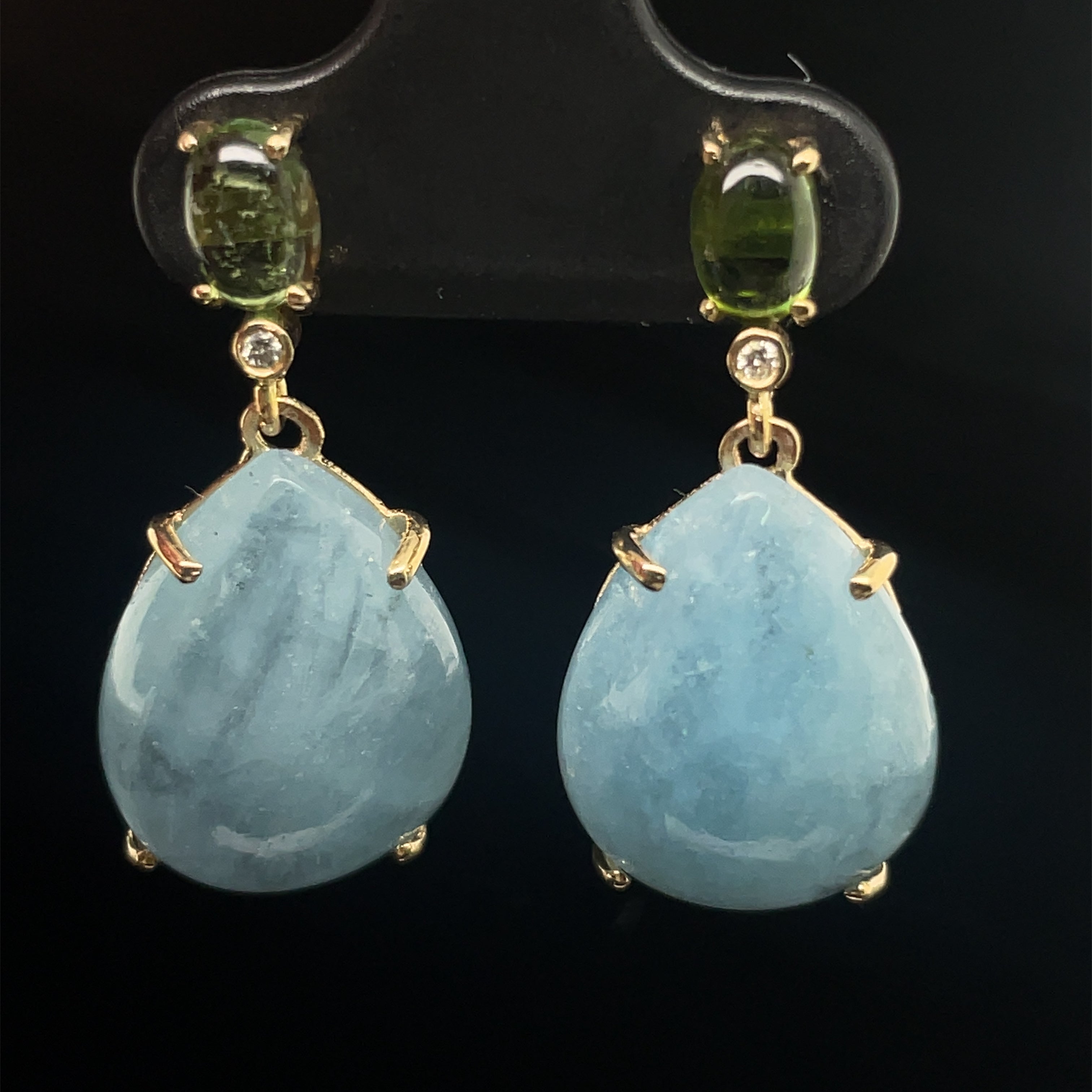 These precious earrings are securely set in 14k yellow gold to showcase the glimmering hues of the aquamarine cabochons and tourmalines, creating a stunning combination of beauty and elegance. 27 x 13 mm with secure friction backs.