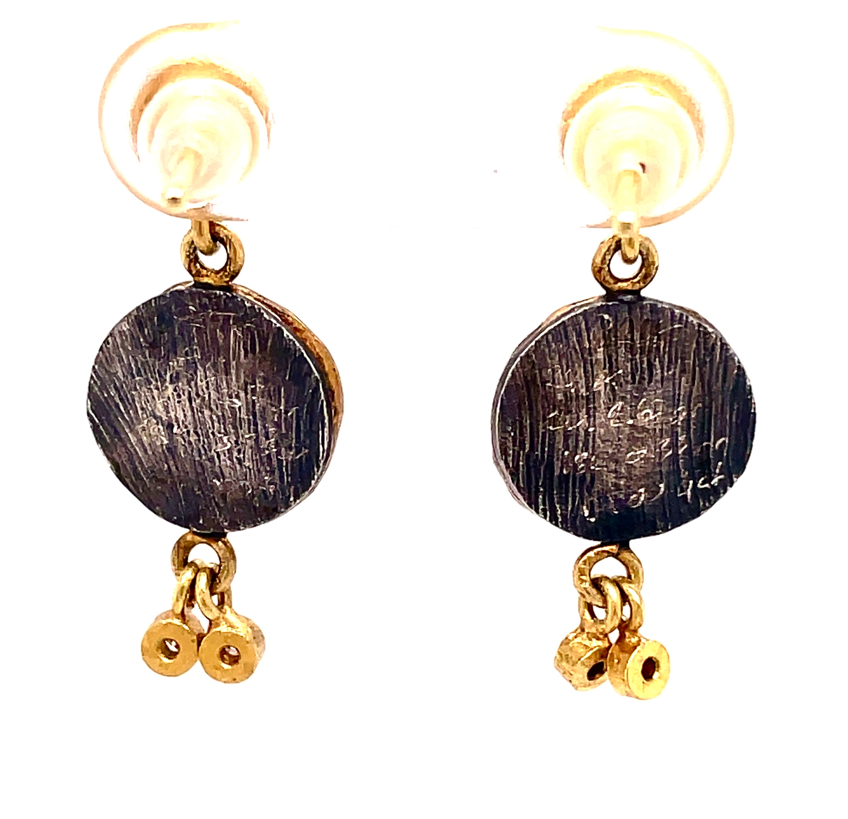 Featuring Turkish craftsmanship, these 26mm earrings boast a combination of 24K yellow gold and oxidized sterling silver. Each earring is embellished with two small round diamonds, the discs evoke the duality of the Istros coins which were once used as theater tickets in Ancient Rome.