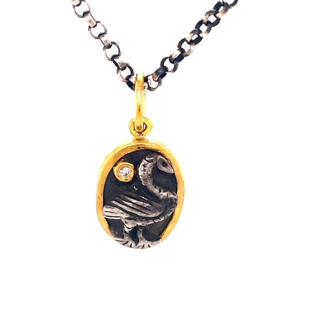 This exquisite handmade pendant is crafted from 24k gold, sterling silver and a small round diamond in an oval coin shape. The matte finish and secure bail makes for a timeless classic design that is sure to be a treasured heirloom. Complete the look with an optional 20" oxidized sterling silver chain ($90.00) for an extra special touch.