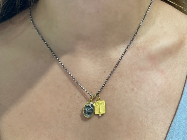 This 24k gold Lion face pendant symbolizes courage and is crafted in a rectangular coin style and is 18.50mm in size. It features a small round diamond and has a matte finish. Handmade in Turkey, it is available with an optional 20" long oxidized sterling silver chain with a secure lobster catch ($90). 
