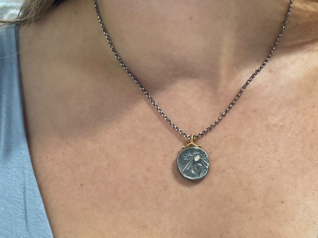 This Queen Bee pendant features a round diamond, 24K gold, and a matte finish. Handcrafted in Turkey, it can be paired with an optional Oxidized sterling silver chain with a secure lobster catch ($75). The pendant measures 18.50 mm and the chain is 17" long.