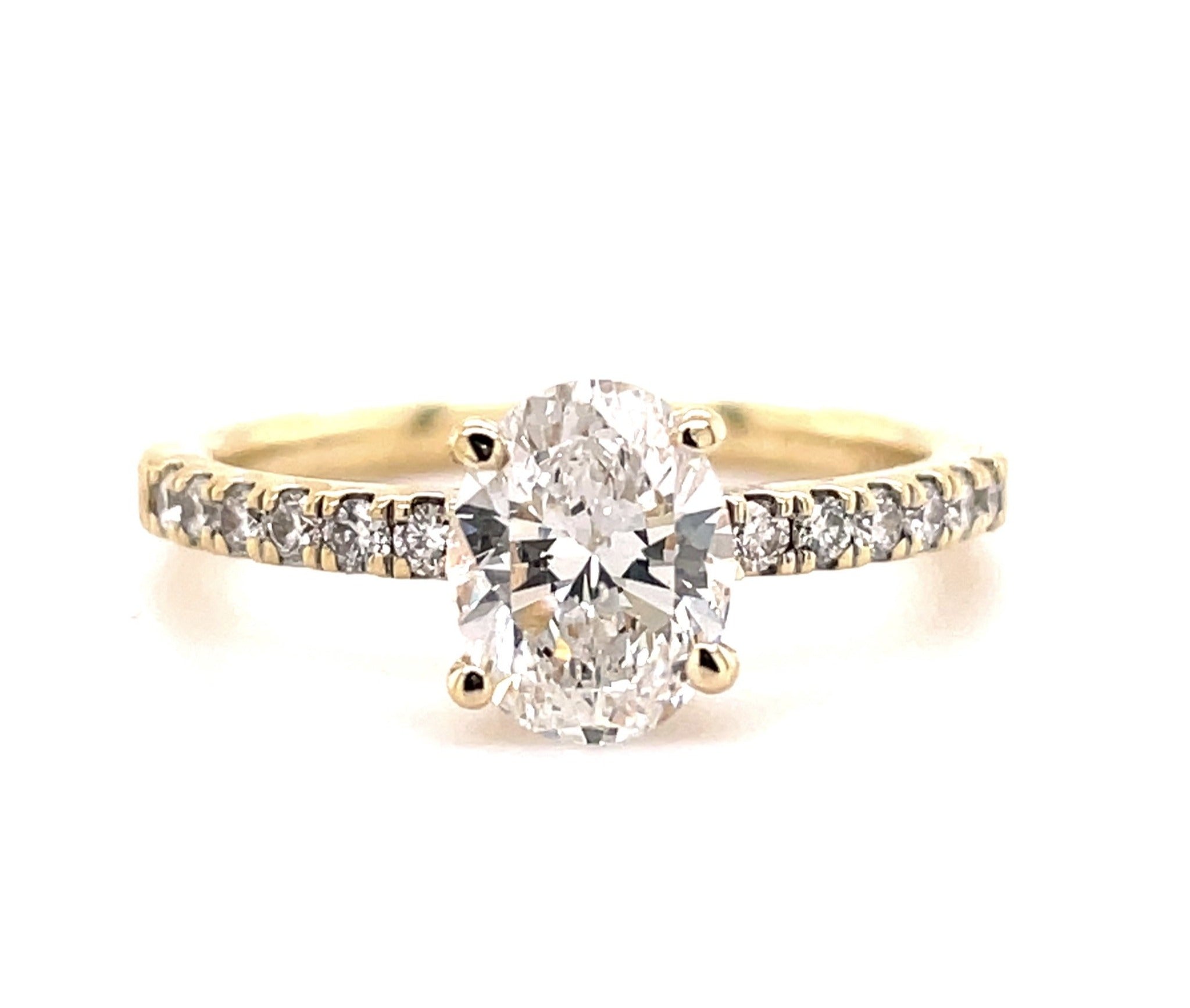 A delicate and modern oval cut diamond glitters with the illusion of a bigger size, making 0.93 cts, Color F/G and Clarity SI1 beautiful and eye-catching. Set in a four-prong mounting of 14k yellow gold with an entrancing diamond band of 0.28 cts, this Custom Made Oval Cut Engagement Ring is simply divine!