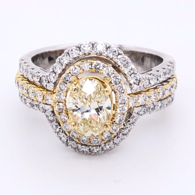 A breathtakingly beautiful oval yellow diamond is set in a luxurious 14k two tone gold mounting. The center stone weighs 1.10 cts with an eye-catching Fancy Yellow hue and VS2 clarity. A double halo and three rows of diamonds weighing a total of 1.04 cts with F/G color and VS1 clarity add to the stunning design. This exquisite ring is sized at 5.5 and can be resized.