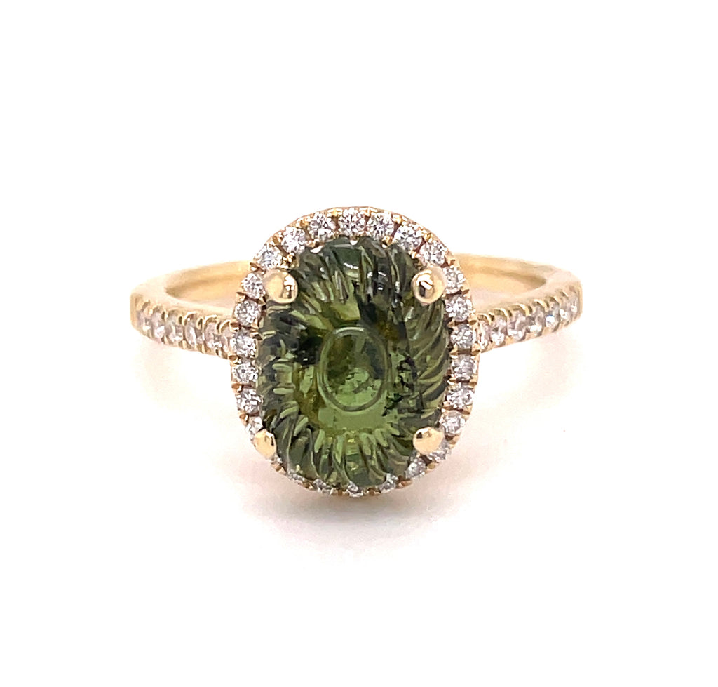 This stunning Carved Oval Green Tourmaline Diamond Halo Ring is crafted from 14k yellow gold and features a round green tourmaline encircled by 0.45 cts of white round diamonds. Size 6.5 and 11.00 mm.