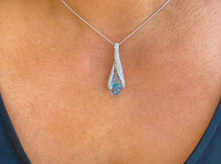 This elegant pendant necklace features a briolette-cut blue topaz, round 1.53 cts diamonds set in 18 karat white gold, with a 14 karat white gold chain link and secure lobster clasp measuring 16 inches in length.