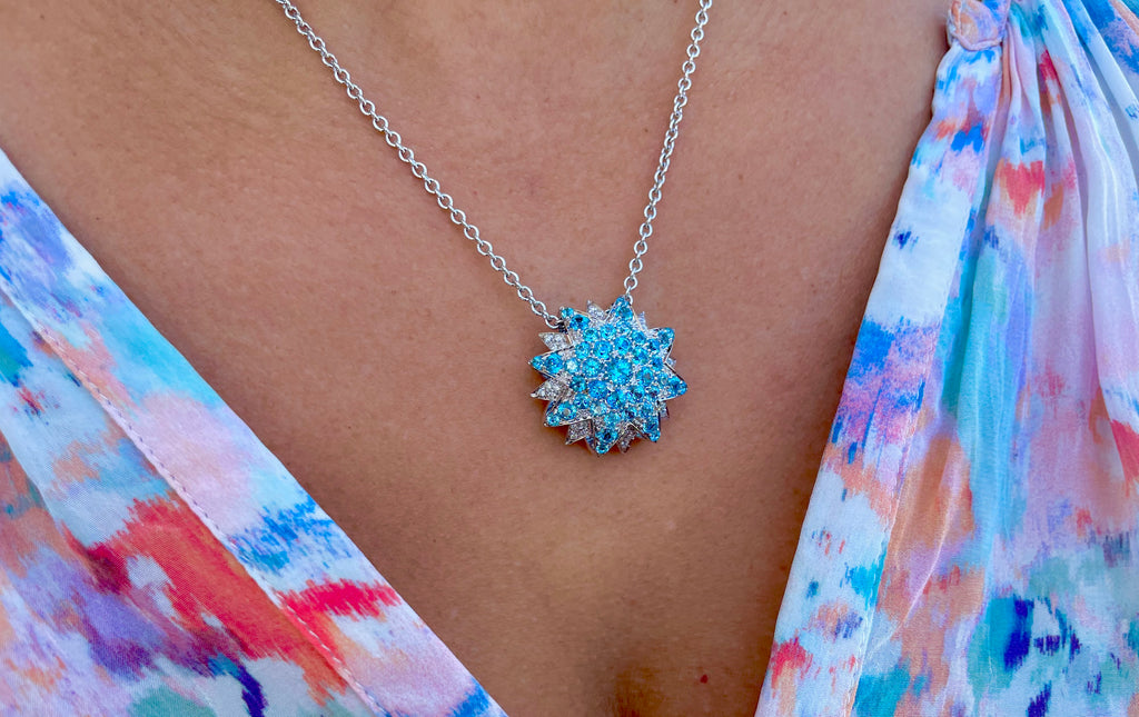 Sunburst shape pendant  Slider systerm  Italian made from Bossio Bruni Collection  Round blue topaz 1.50 cts  Round diamonds 1.00 cts  18k white gold  14k white gold rolo link chain with secure lobster clasp  18" long