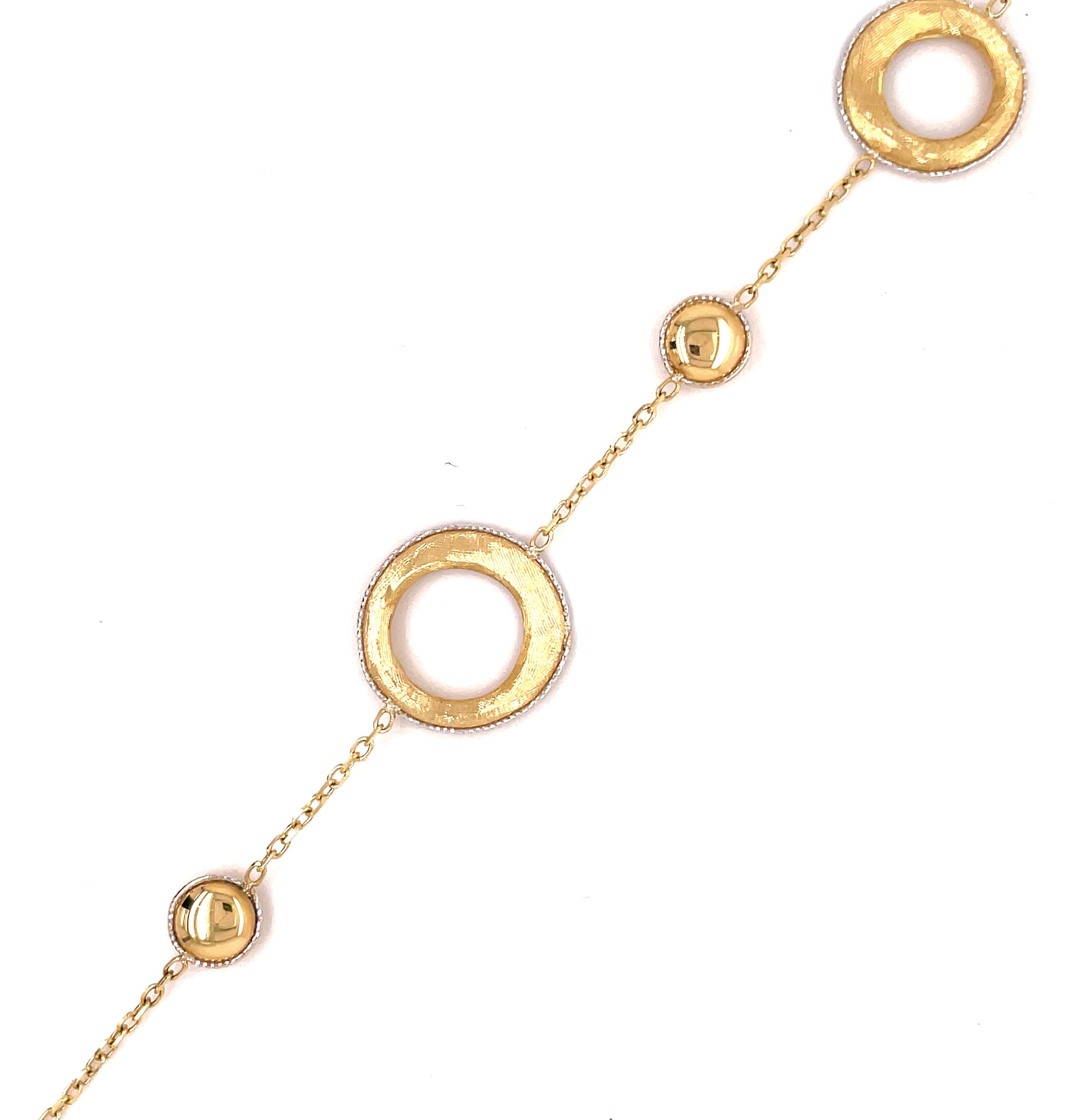 Made from 14k yellow and white gold, this 7" long bracelet features a 16.00mm large circle, which is fastened with a secure lobster catch. White gold is featured at the edge of the circle, adding a special sparkle.