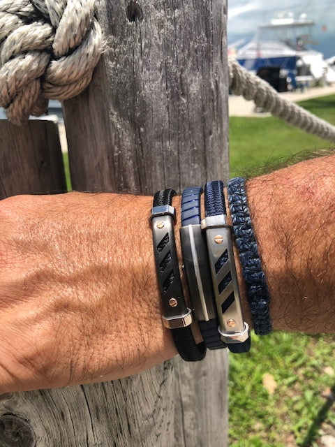 This Italian-made stainless steel bracelet with a secure adjustable clasp measures 8" in length and boasts rose gold screws for a sophisticated, sporty aesthetic. The sleek black polyester provides a modern touch.