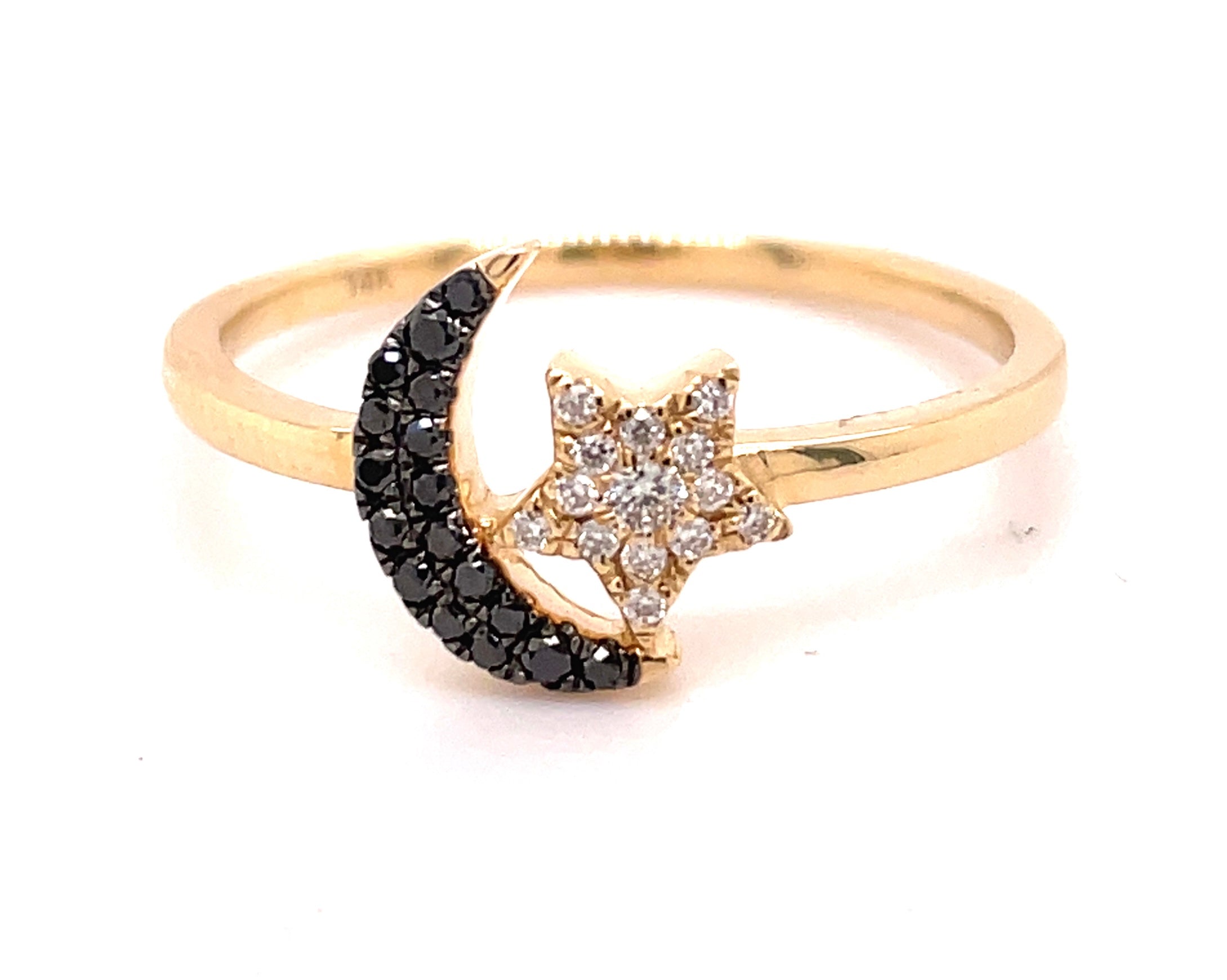 Crafted from 14k yellow gold, this ring features a moon and star design, decorated with 0.13 carats of round black diamonds.