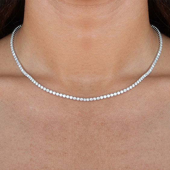 ndulge in luxury with our Diamond Tennis Necklace. Featuring a dazzling 7.00 cts of stunning round diamonds in a captivating 14k white gold block setting. The secure lobster catch adds a touch of sophistication to the 17" long necklace. Elevate any outfit with the elevated elegance of this necklace.