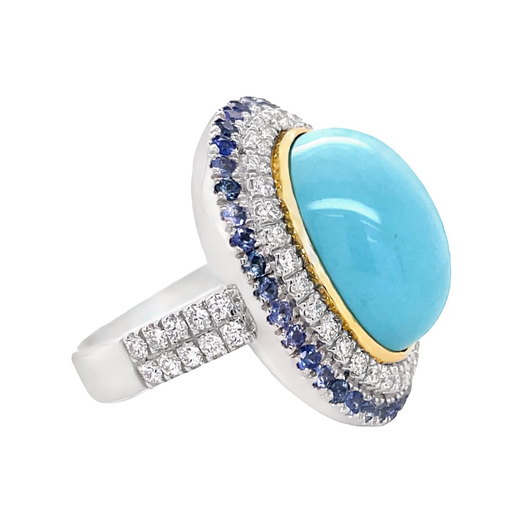 Italian handcrafted ring  Set in 18k white gold  Gallery design at the back  Turquoise cabochon 18.00 x 13.00 mm  White round diamonds 1.29 cts  Round blue sapphires 1.19 cts  Double diamond band  27.50 mm lenght